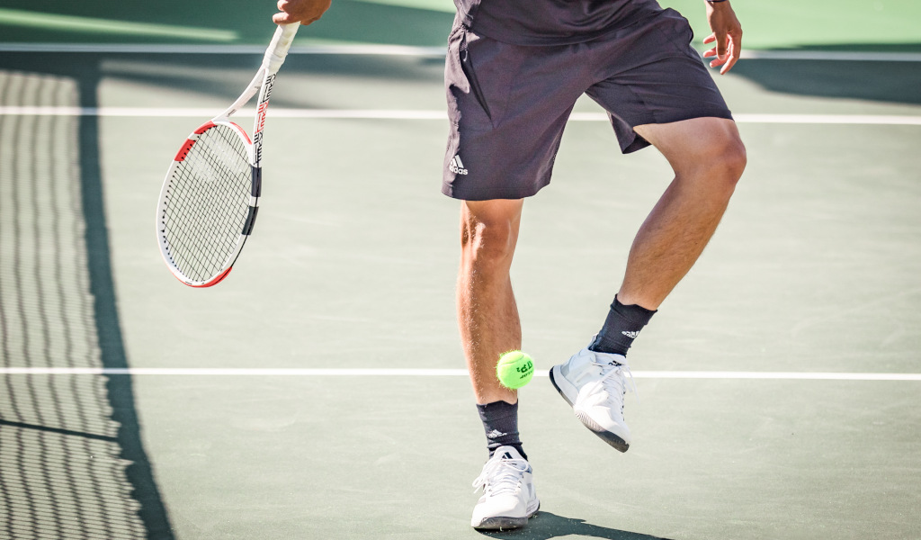Tennista su un campo a Tenerife, che colpisce una palla con la racchetta.