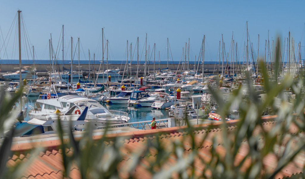 Barche ormeggiavano nel porto di Los Cristianos, Tenerife, con il mare sullo sfondo.