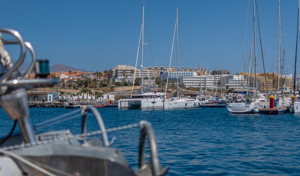 Marina a Costa Adeje, Tenerife, con yacht e edifici sullo sfondo.