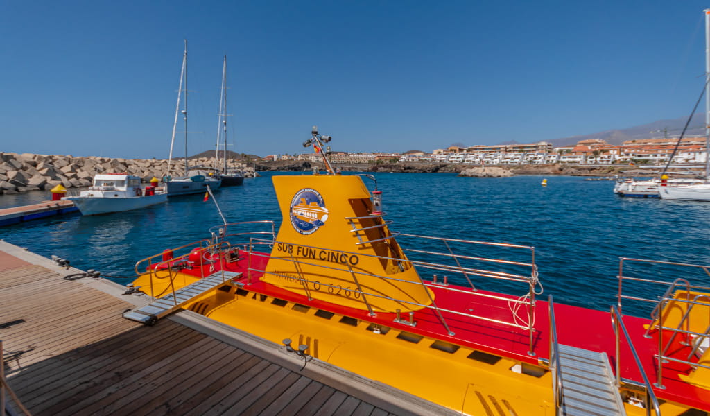 Sottomarino giallo attraccato nel porto di Puerto de la Cruz, Tenerife, con barche sullo sfondo.
