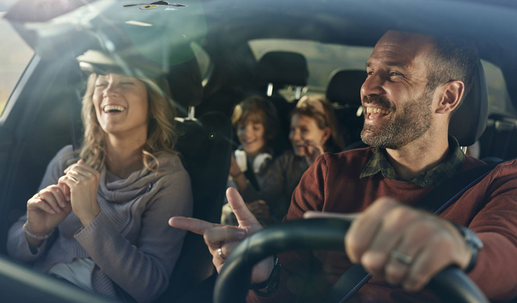 Famiglia sorridente che viaggia in auto a Tenerife.