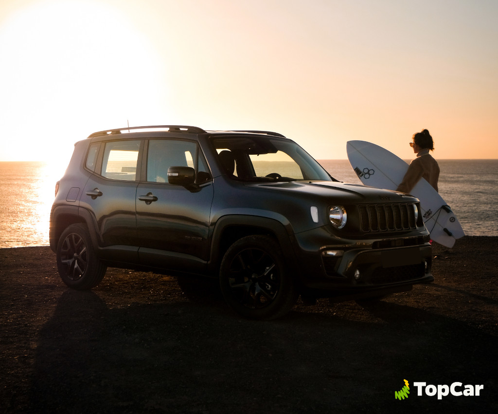 Auto parcheggiata al tramonto accanto a un surfista sulla costa di Tenerife.