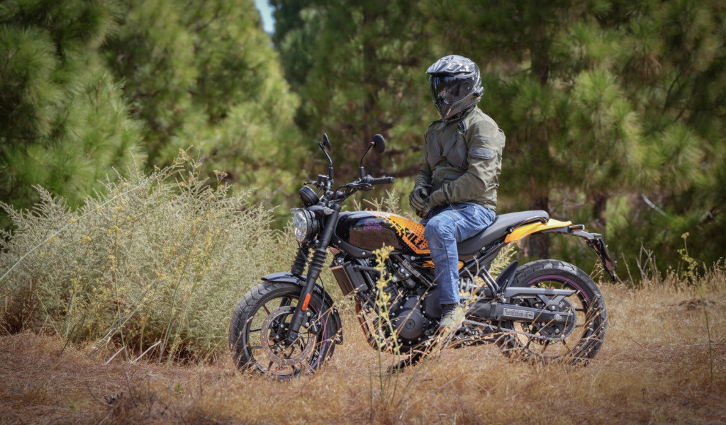 Persona con il casco seduta su una moto su una strada forestale a Tenerife.