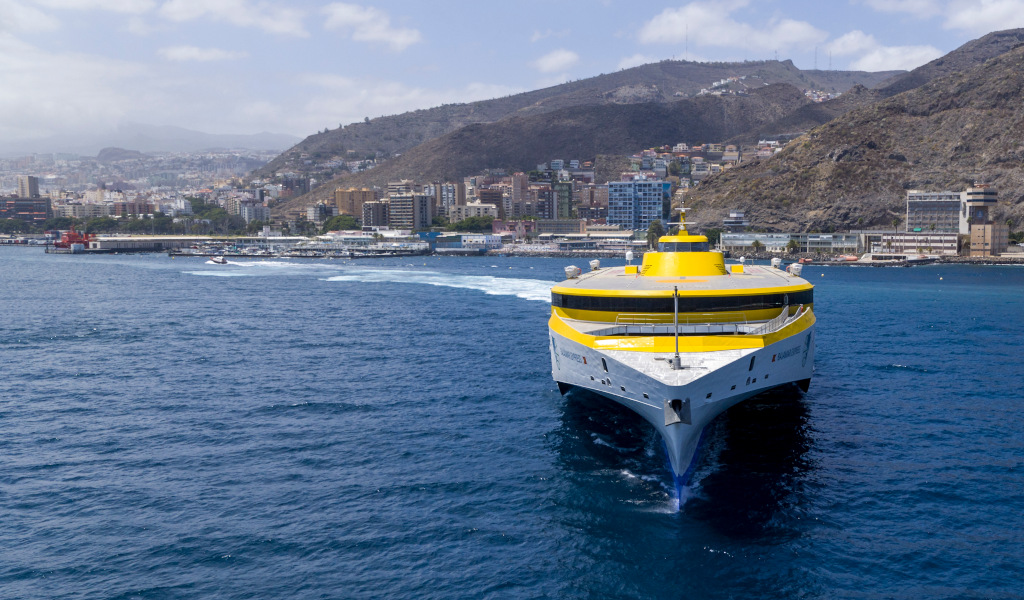 Traghetto giallo nel porto di Santa Cruz de Tenerife con la città sullo sfondo.