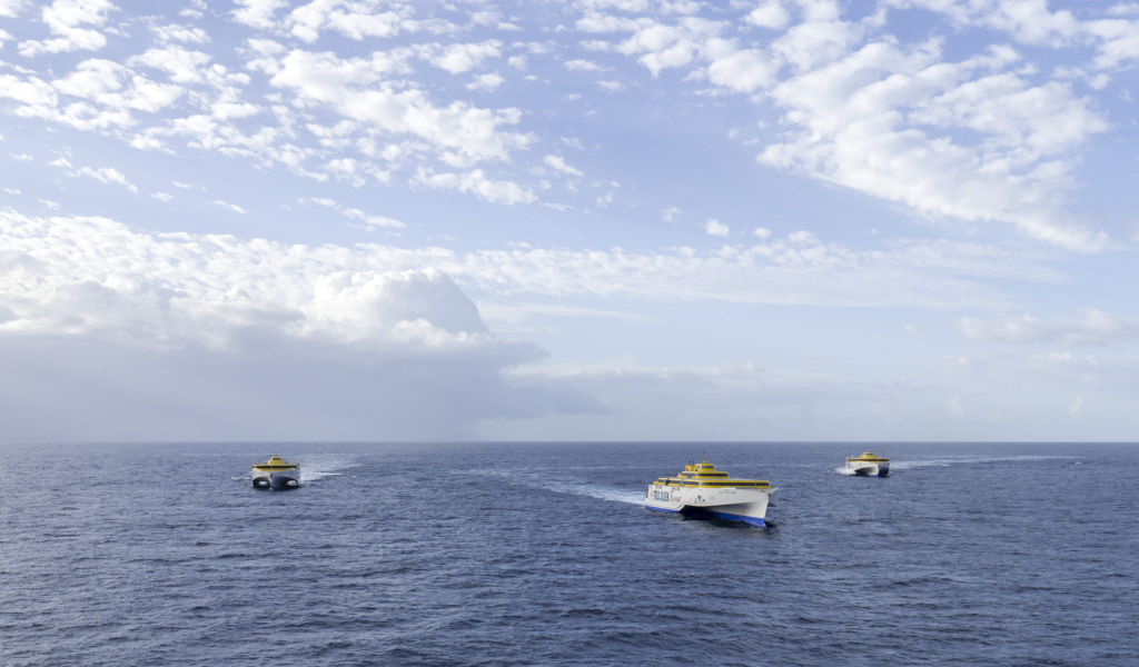 Tre traghetti nell'oceano vicino a Tenerife sotto cieli nuvolosi.