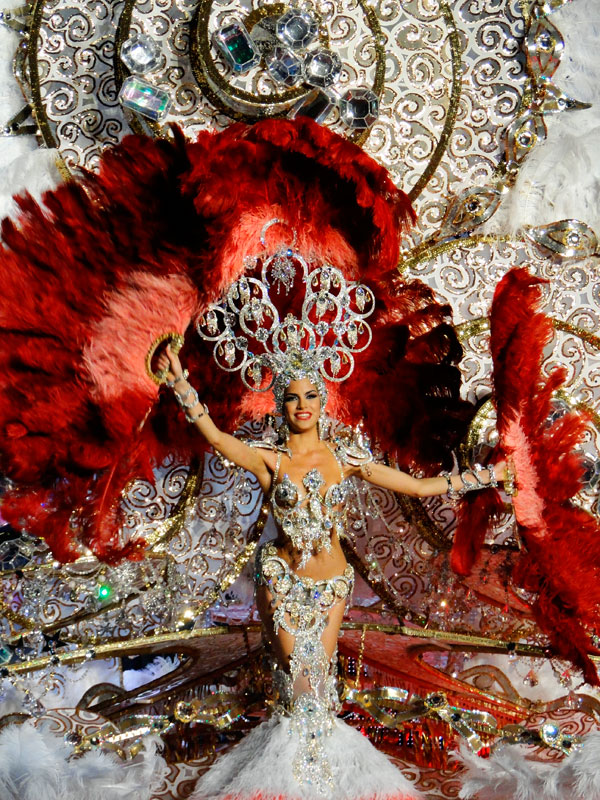 Compagnia di carnevale a Tenerife con costume vivace e grandi piume rosse.