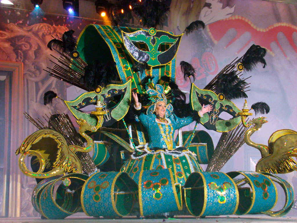 Persona in costume colorato con maschere e piume durante il carnevale a Tenerife.
