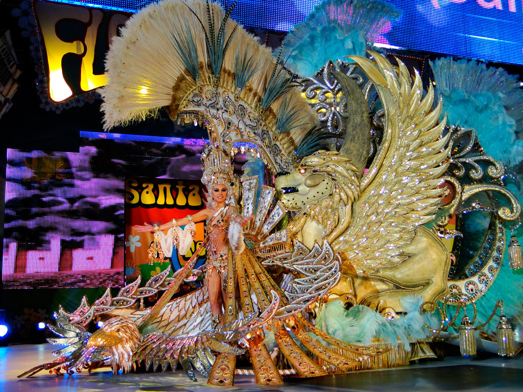 Personaggio in costume festivo dorato con ornamenti di piume e leone alato a Santa Cruz de Tenerife.