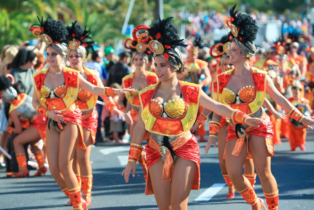 Persone che sfilano in costumi colorati al Carnevale di Tenerife.