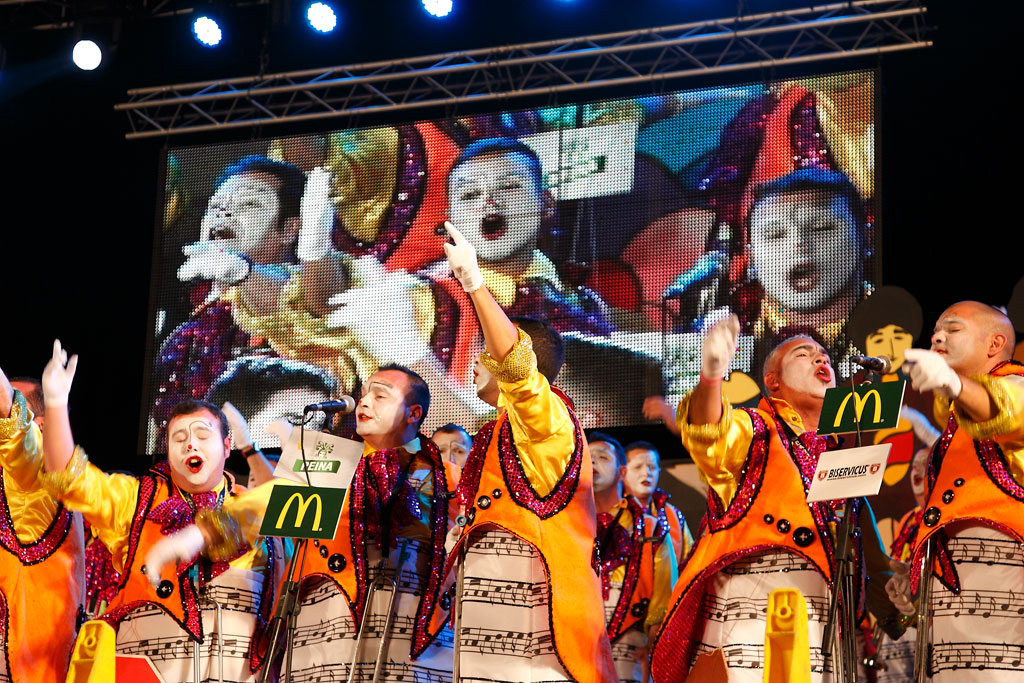 Esibizione musicale durante un carnevale a Tenerife con costumi colorati e canto di gruppo.