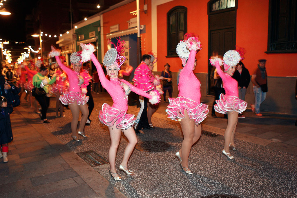 Ballerini in costumi rosa sfilano durante un carnevale notturno a Tenerife.