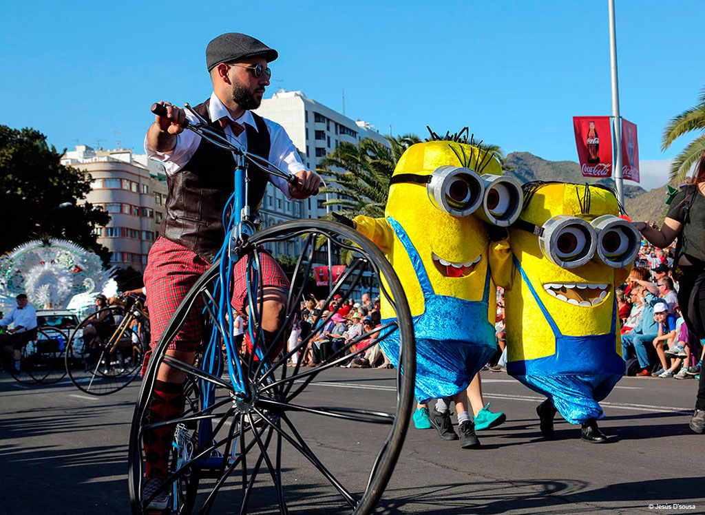 Sfilare con persone travestite da personaggi gialli e ciclisti su una vecchia bicicletta a Tenerife.