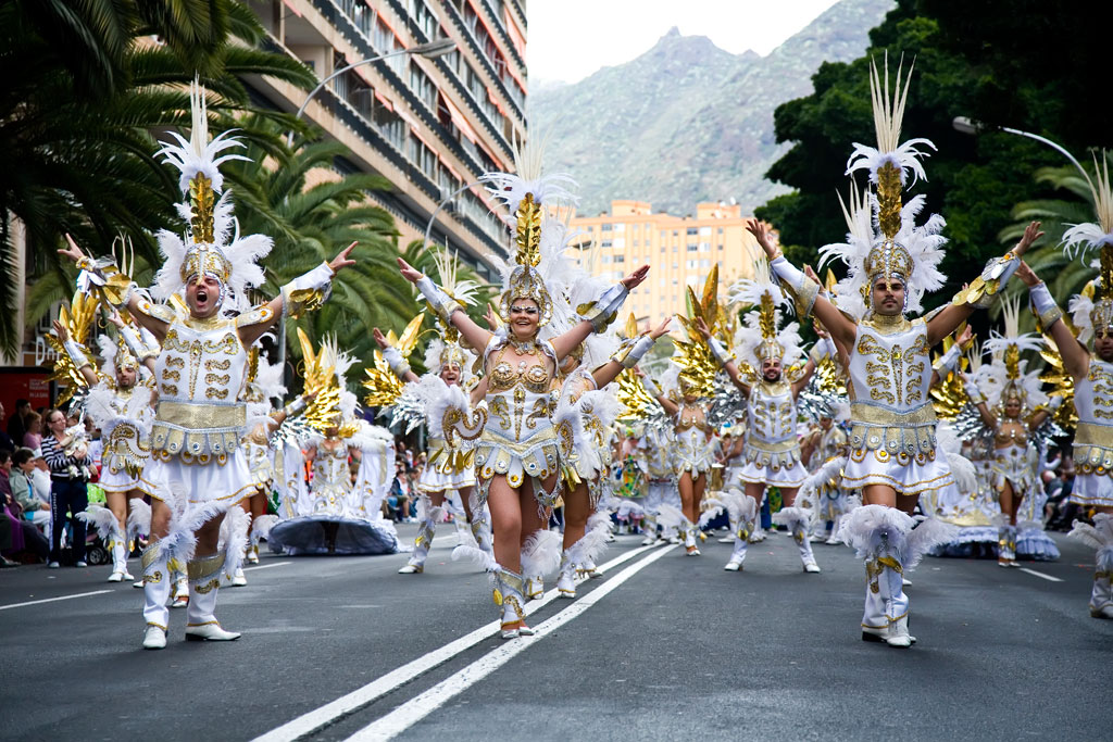 Gruppo di persone in costumi da carnevale oro e bianco che sfilano a Santa Cruz de Tenerife.