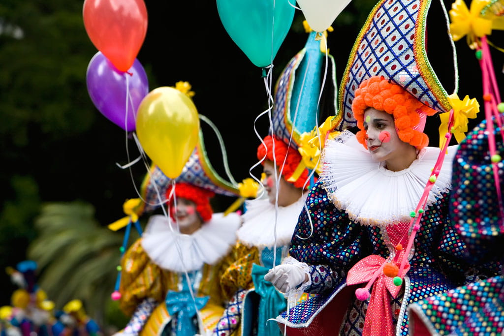 Persone vestite da mimi con palloncini colorati durante una parata a Tenerife.