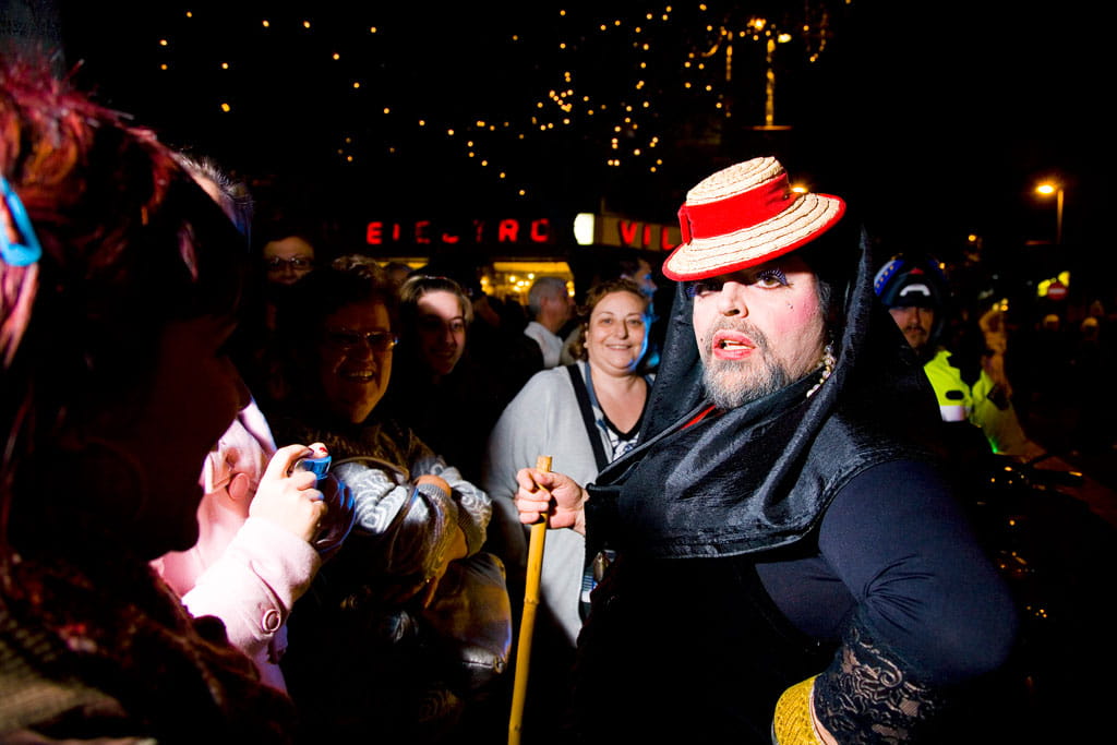 Persona in costume e gruppo che festeggiano di notte a Santa Cruz de Tenerife.