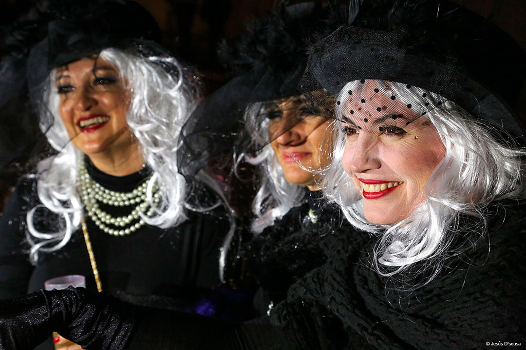 Persone vestite con parrucche bianche e cappelli neri al carnevale di Tenerife.