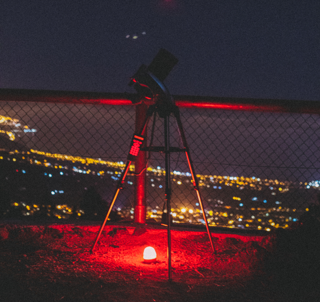 Telescopio in punto panoramico con luci notturne urbane a Tenerife.