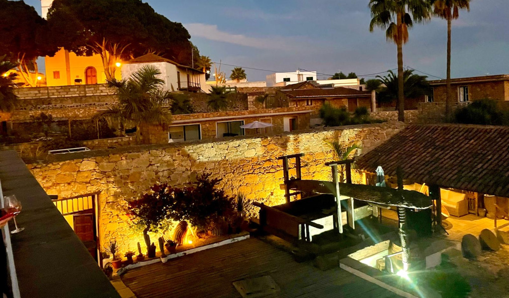 Cortile illuminato con muri in pietra e verde in una casa a Tenerife.