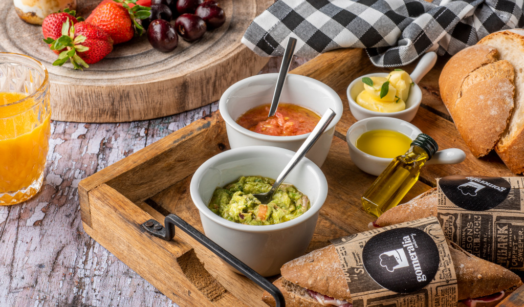 Colazione con frutta, succo d'arancia, guacamole, pane e olio d'oliva a Tenerife.