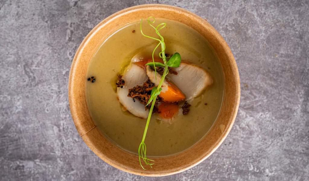 Zuppa cremosa con verdure e germogli verdi in una ciotola su un tavolo di pietra a Tenerife.