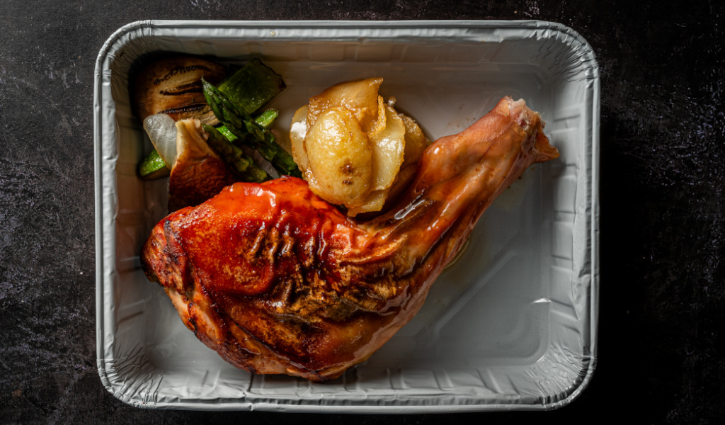 Pollo arrosto con verdure e patate su una teglia di alluminio a Tenerife.