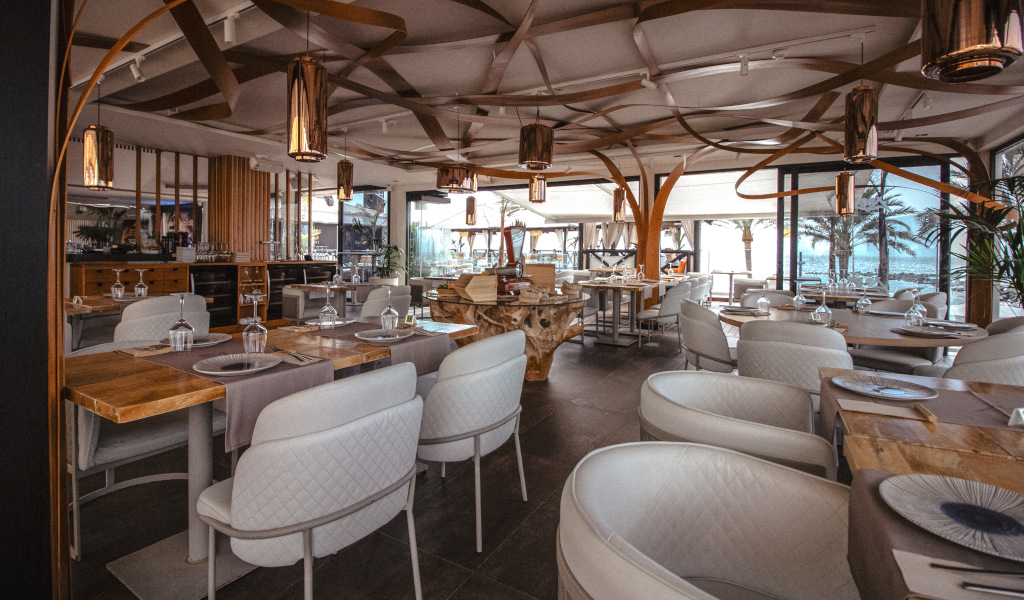 Ristorante elegante con tavoli preparati a Tenerife, vista esterna con palme.