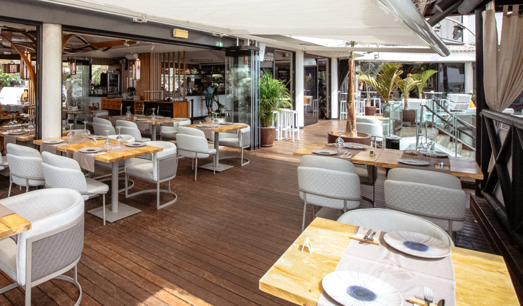 Terrazza ristorante a Tenerife con tavoli e sedie, arredamento moderno.