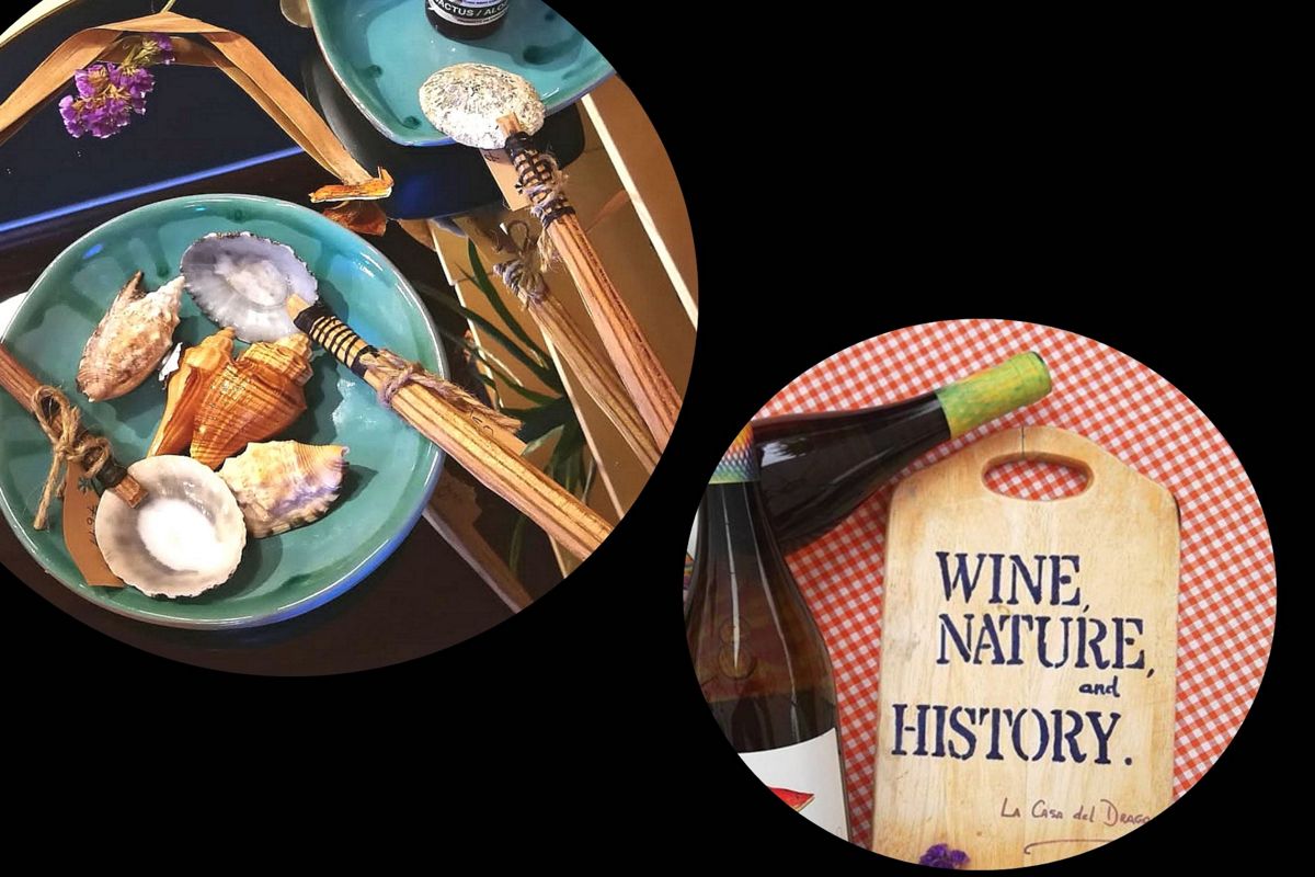 Piatti di conchiglie e bottiglia accanto a un tavolo con il testo VINO, NATURA e STORIA a Tenerife.