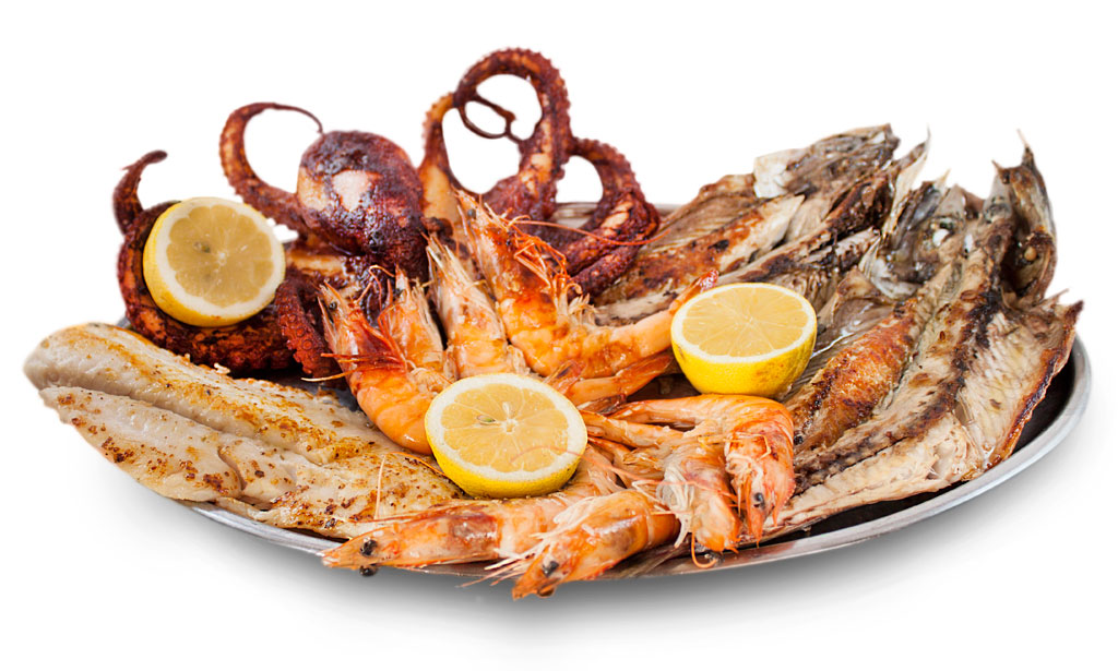 Piatto di pesce vario con gamberi, pesce e spicchi di limone a Tenerife.