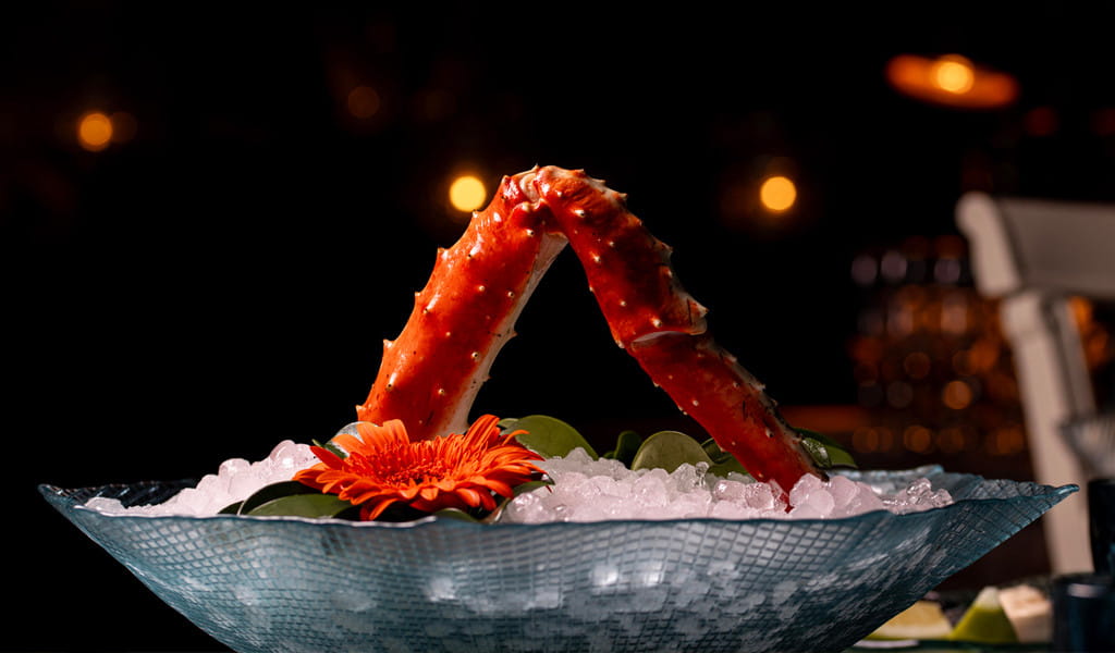 Zampe di granchio sul ghiaccio con fiori decorativi in un ristorante a Tenerife.
