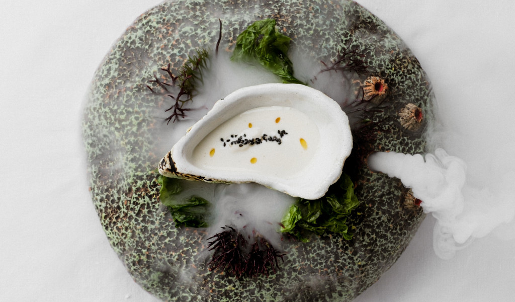 Piatto di pesce con panna bianca, alghe e semi a Tenerife.