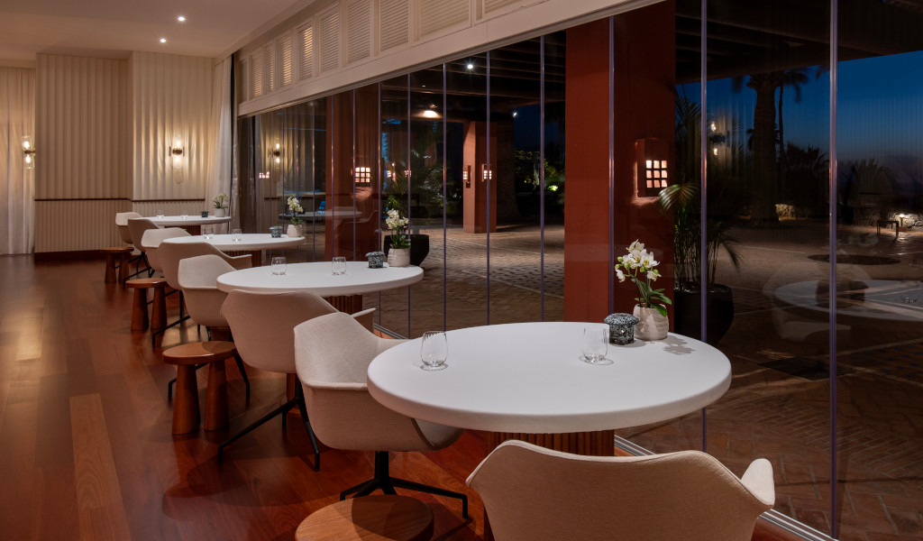 Tavoli da pranzo e sedie accanto a grandi finestre in un elegante ristorante a Tenerife.