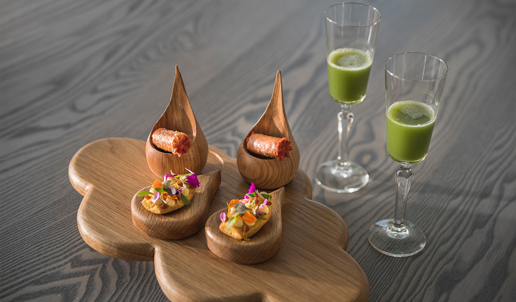 Varietà di antipasti gourmet e bicchieri con succo verde su un tavolo a Tenerife.