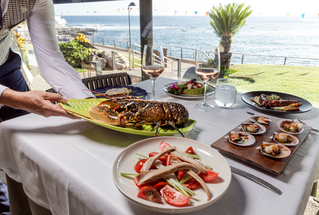Piatti di pesce e vino in un ristorante con vista sul mare a Tenerife.