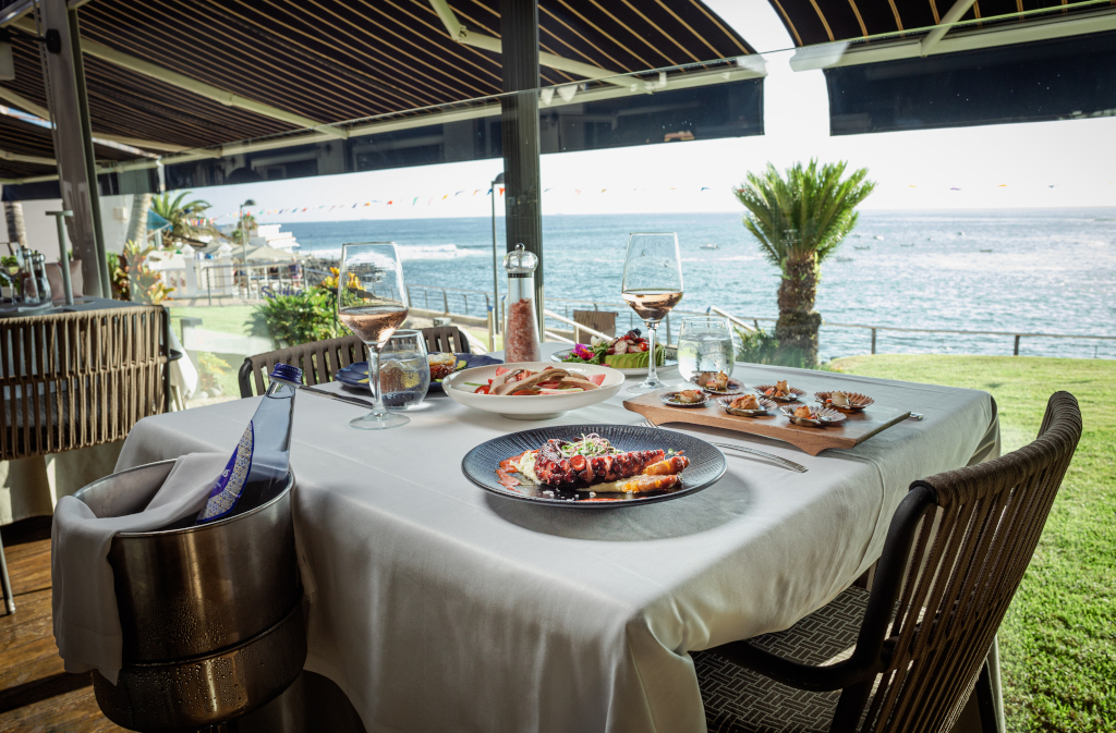 Tavolo ristorante con piatti gourmet e vista sul mare a Tenerife.