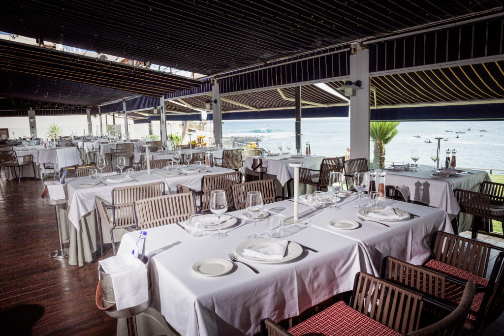 Ristorante con tavoli preparati di fronte al mare a Tenerife.