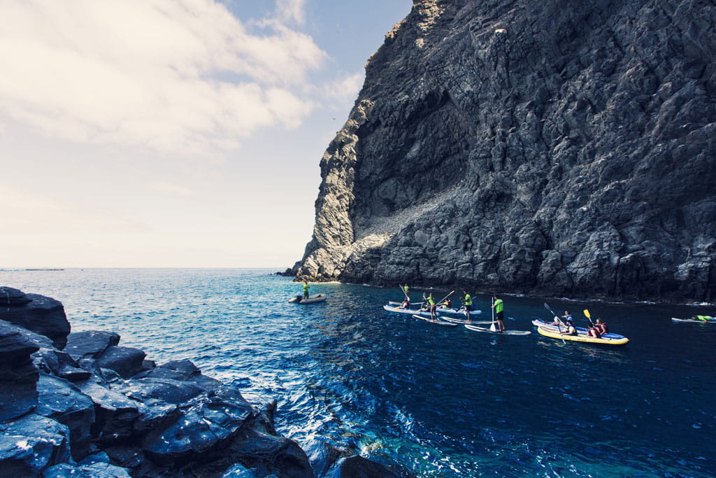 Persone che fanno paddle board vicino a una scogliera a Tenerife.