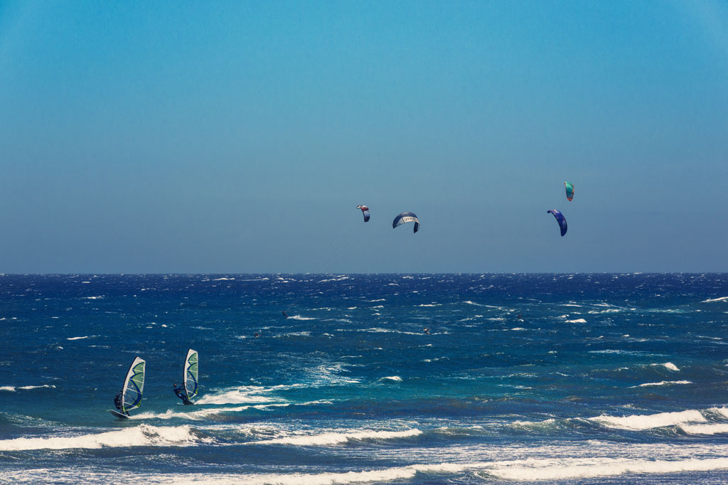 Le persone praticano kitesurf e windsurf a El Médano, Tenerife.