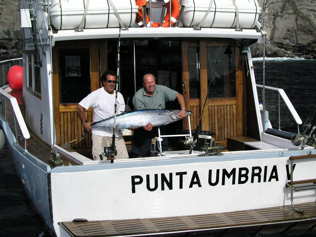 Le persone su una barca da pesca a Punta Umbria tengono un grosso pesce al largo della costa di Tenerife.