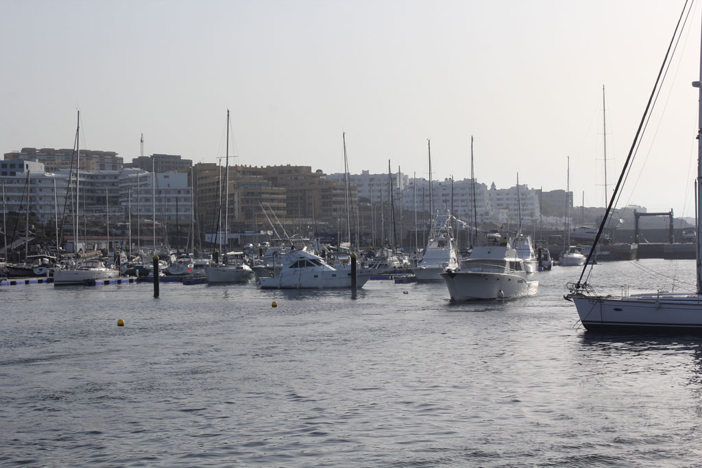 Barche nel porto di Los Cristianos, Tenerife, con edifici sullo sfondo.