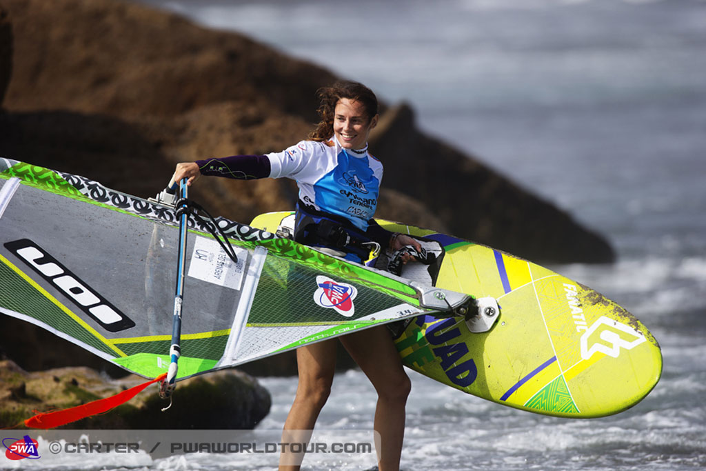 Persona con attrezzatura da windsurf sulla spiaggia di Tenerife.