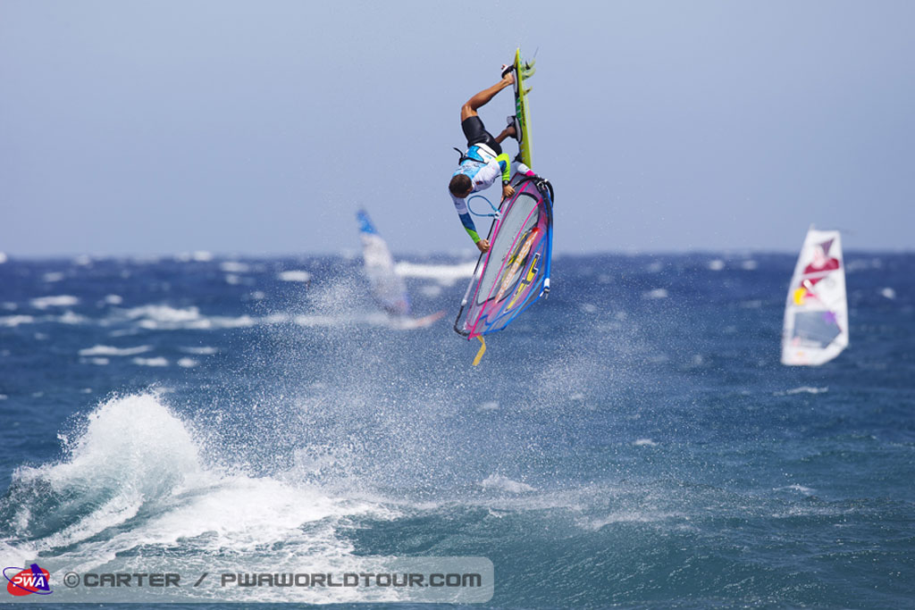 Persona che fa windsurf a El Médano, Tenerife, con vele di mare e altre vele sullo sfondo.