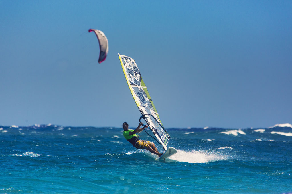 Surfista che fa windsurf nel mare di Tenerife sotto un cielo limpido.