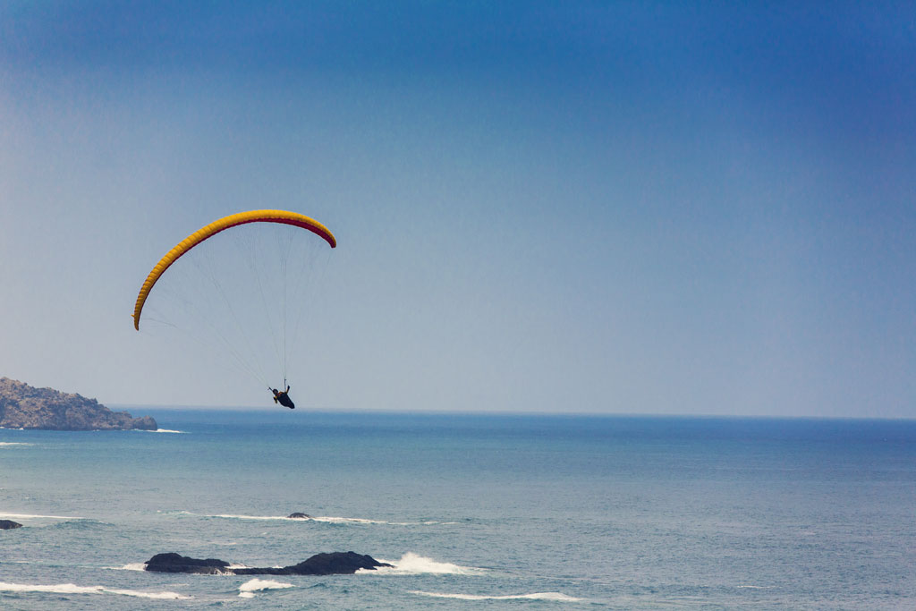 Parapendio sulla costa di Tenerife con l'oceano sullo sfondo.