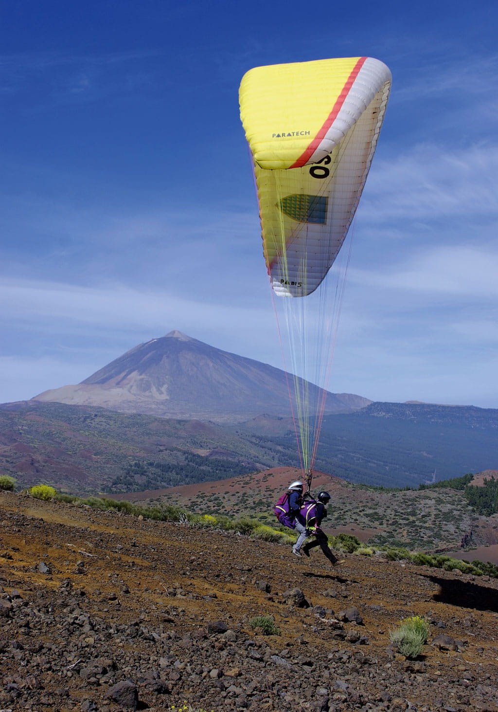 Parapendio sopra il paesaggio del Teide a Tenerife con due piloti.
