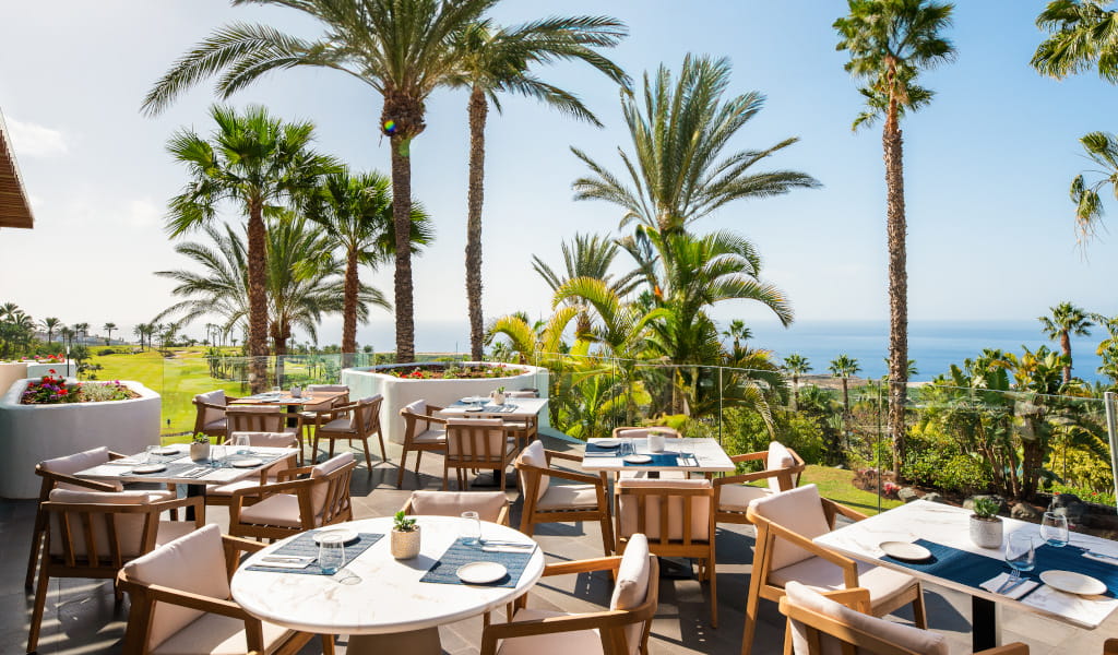 Terrazza ristorante con vista sul mare e palme a Tenerife.