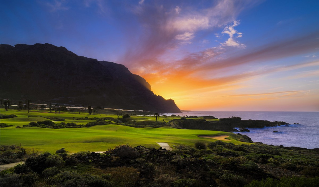 Tramontare su un campo da golf a Tenerife sul mare.