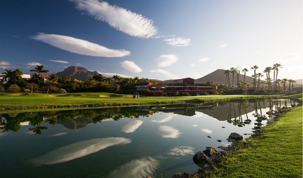 Campo da golf con montagne e palme riflesse in un lago a Tenerife.