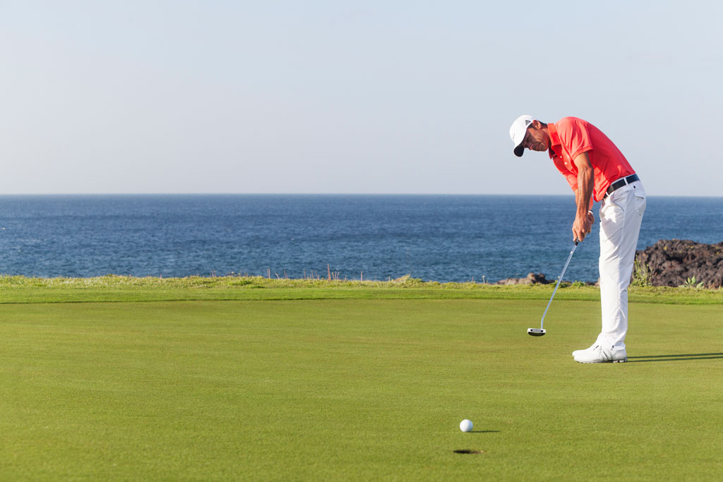 Persona che gioca a golf sul mare a Tenerife.