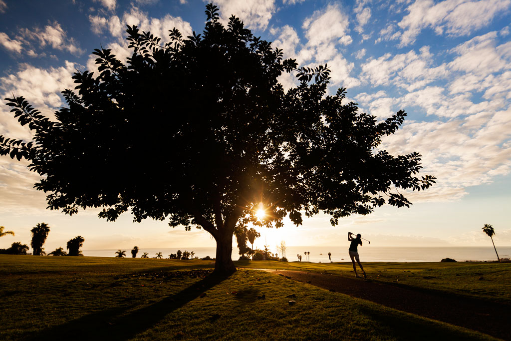 Persona che gioca a golf al tramonto su un campo a Tenerife.